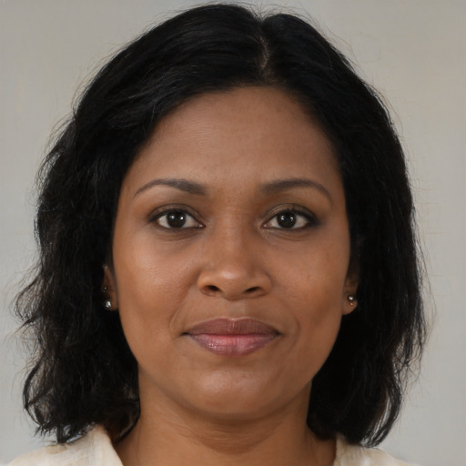 Joyful black adult female with medium  brown hair and brown eyes