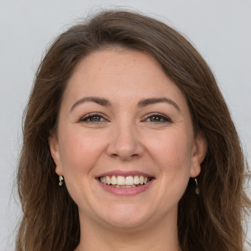 Joyful white adult female with long  brown hair and brown eyes