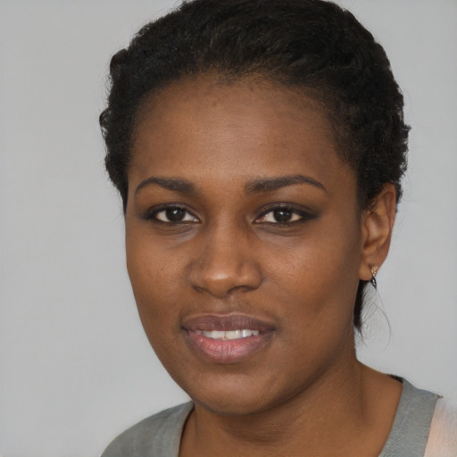 Joyful black young-adult female with short  black hair and brown eyes