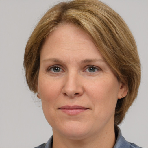 Joyful white adult female with medium  brown hair and blue eyes