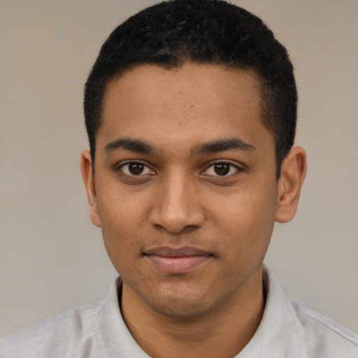 Joyful black young-adult male with short  black hair and brown eyes
