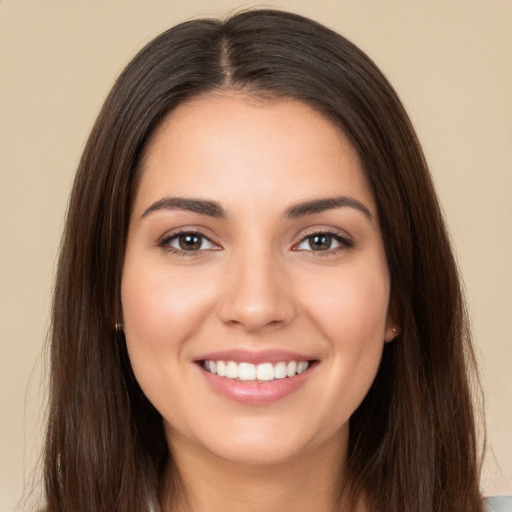 Joyful white young-adult female with long  brown hair and brown eyes