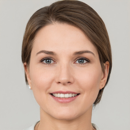 Joyful white young-adult female with short  brown hair and grey eyes