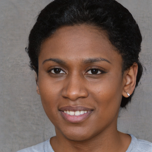 Joyful black young-adult female with short  brown hair and brown eyes