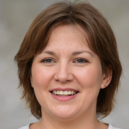 Joyful white adult female with medium  brown hair and grey eyes