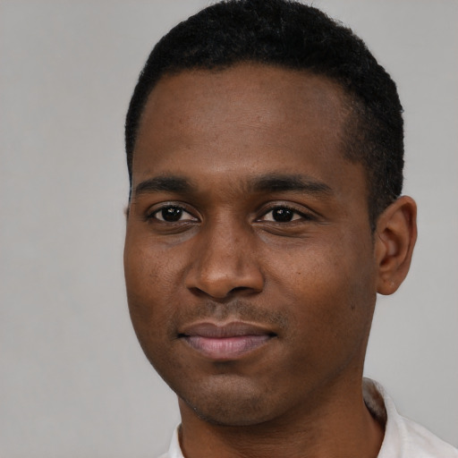 Joyful black young-adult male with short  black hair and brown eyes
