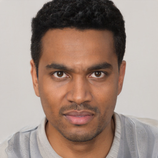 Joyful black young-adult male with short  black hair and brown eyes