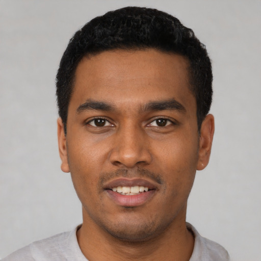 Joyful latino young-adult male with short  black hair and brown eyes