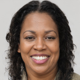 Joyful black adult female with long  brown hair and brown eyes