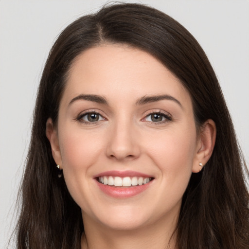 Joyful white young-adult female with long  brown hair and brown eyes