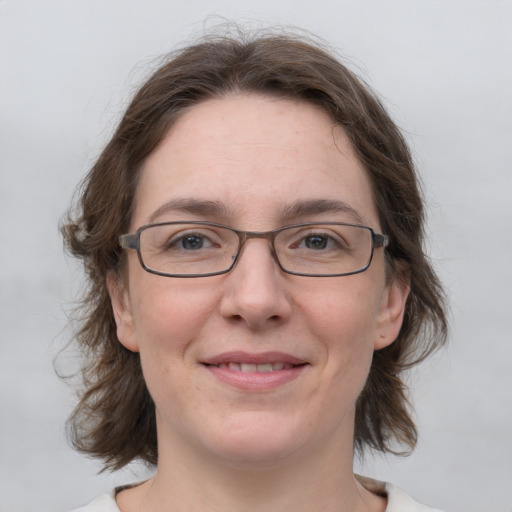 Joyful white adult female with medium  brown hair and grey eyes