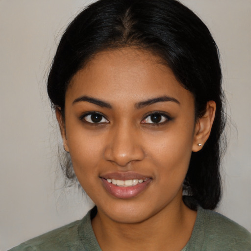 Joyful black young-adult female with medium  black hair and brown eyes