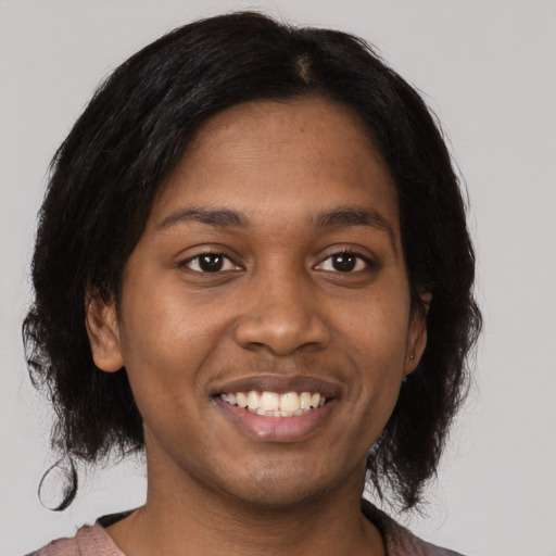 Joyful black young-adult female with medium  brown hair and brown eyes