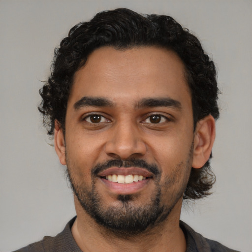 Joyful latino young-adult male with short  black hair and brown eyes