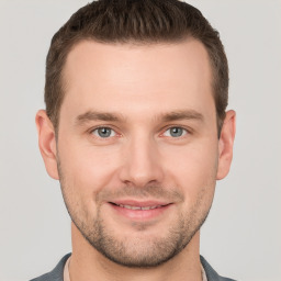 Joyful white young-adult male with short  brown hair and grey eyes