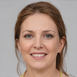 Joyful white young-adult female with medium  brown hair and grey eyes