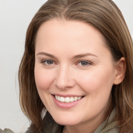 Joyful white young-adult female with long  brown hair and grey eyes