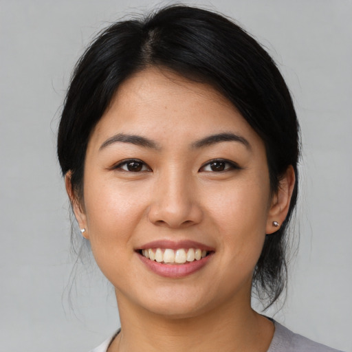 Joyful asian young-adult female with medium  black hair and brown eyes