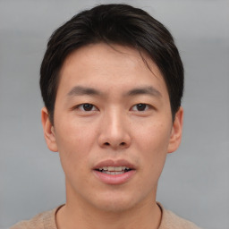 Joyful asian young-adult male with short  brown hair and brown eyes