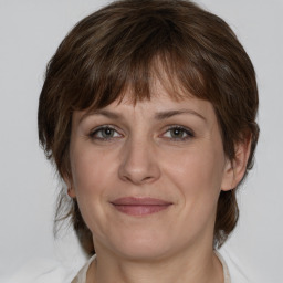 Joyful white adult female with medium  brown hair and grey eyes