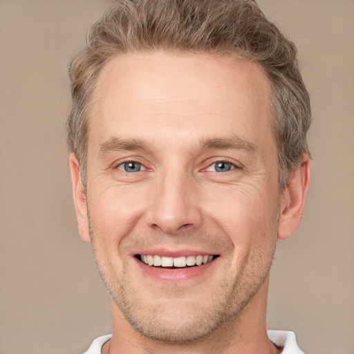 Joyful white adult male with short  brown hair and grey eyes