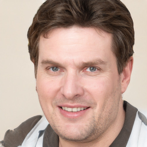 Joyful white adult male with short  brown hair and grey eyes