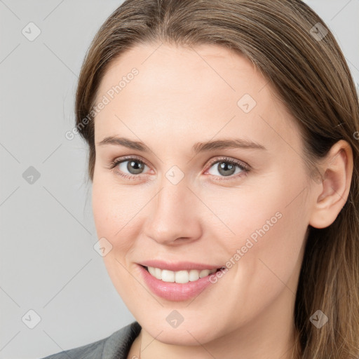 Joyful white young-adult female with long  brown hair and grey eyes