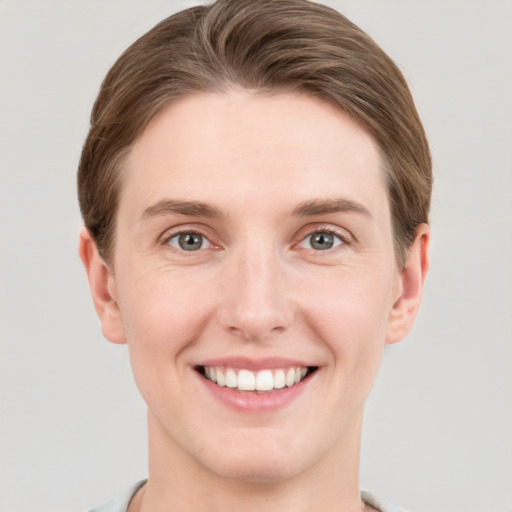 Joyful white young-adult female with short  brown hair and grey eyes