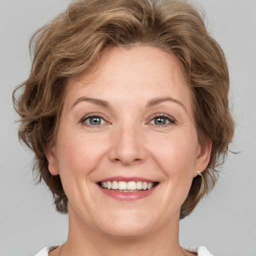 Joyful white adult female with medium  brown hair and green eyes