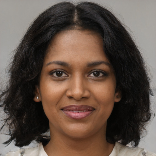 Joyful black young-adult female with medium  black hair and brown eyes