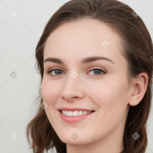 Joyful white young-adult female with long  brown hair and grey eyes