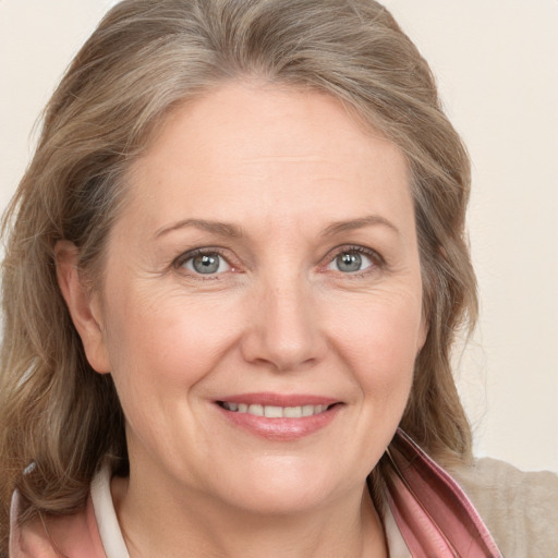 Joyful white adult female with medium  brown hair and grey eyes