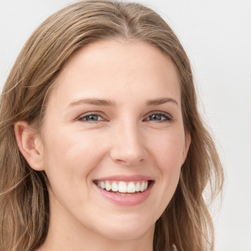 Joyful white young-adult female with long  brown hair and blue eyes