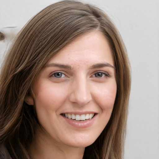 Joyful white young-adult female with long  brown hair and grey eyes