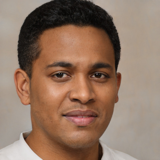 Joyful latino young-adult male with short  brown hair and brown eyes
