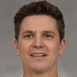 Joyful white adult male with short  brown hair and brown eyes