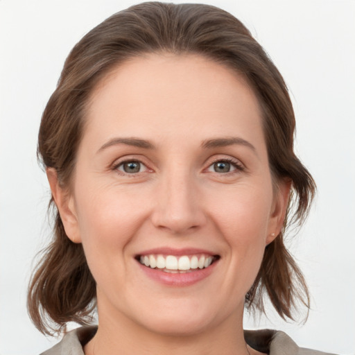 Joyful white young-adult female with medium  brown hair and grey eyes