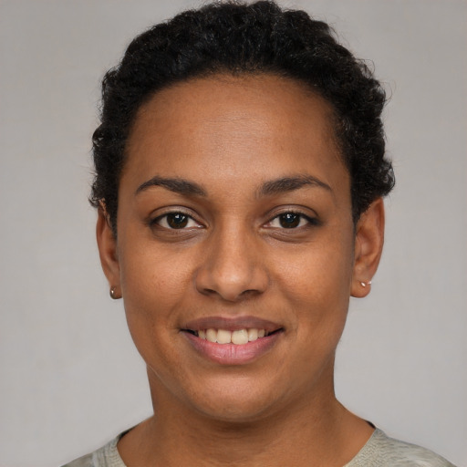 Joyful black young-adult female with short  black hair and brown eyes