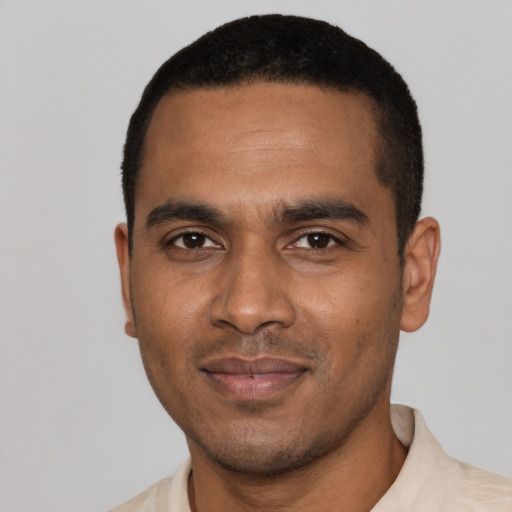 Joyful black young-adult male with short  black hair and brown eyes