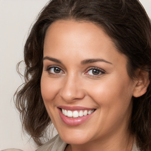 Joyful white young-adult female with long  brown hair and brown eyes