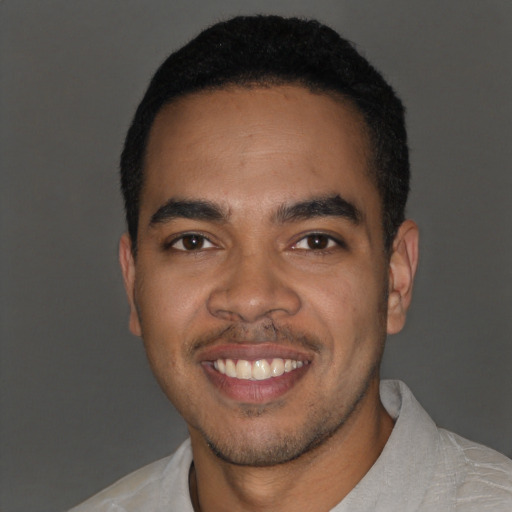 Joyful latino young-adult male with short  black hair and brown eyes