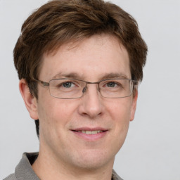 Joyful white adult male with short  brown hair and grey eyes