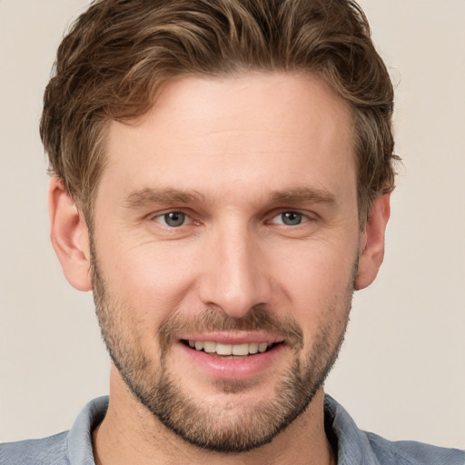 Joyful white young-adult male with short  brown hair and grey eyes