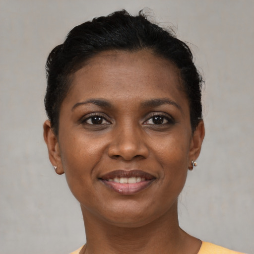 Joyful black young-adult female with short  brown hair and brown eyes