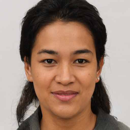 Joyful latino adult female with medium  black hair and brown eyes