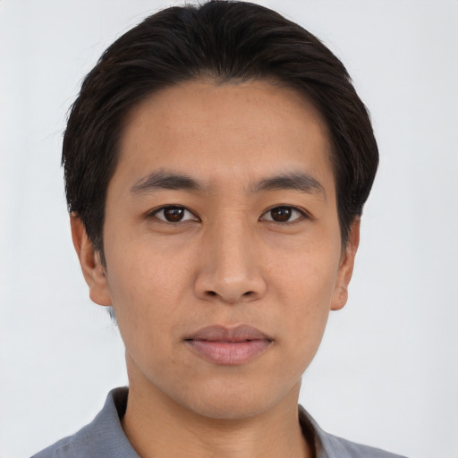 Joyful asian young-adult male with short  black hair and brown eyes