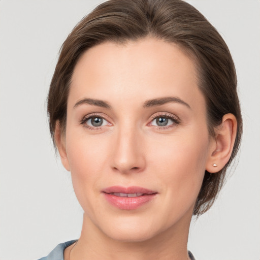 Joyful white young-adult female with medium  brown hair and grey eyes