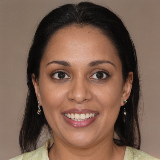 Joyful latino young-adult female with medium  brown hair and brown eyes