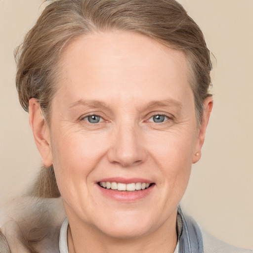 Joyful white adult female with medium  brown hair and grey eyes