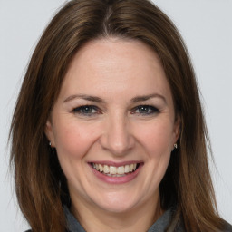 Joyful white adult female with long  brown hair and grey eyes